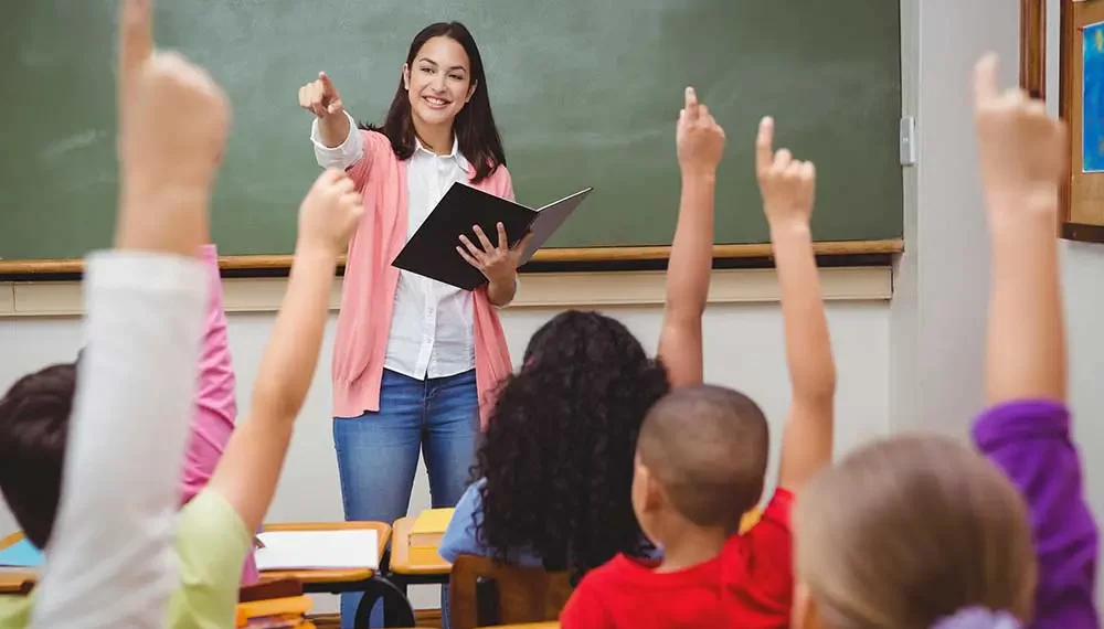 teacher-in-classroom-children-hands-up